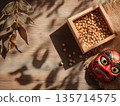 A red demon mask for Setsubun and soybeans in a wooden box placed on a wooden table 135714575