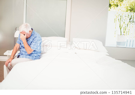 White bedding resting on bed by nightstand and mirrored closet door with window showing greenery White bedding resting on bed by nightstand and mirrored closet door with window showing greenery 135714941