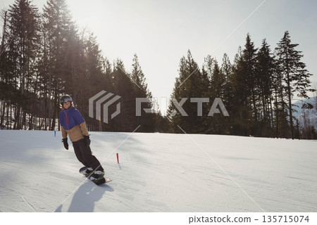 Woman snowboarding on alpine slope wearing helmet goggles gloves near markers, copy space 135715074