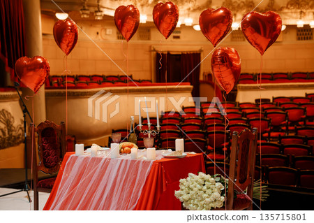 Romantic Valentine's Day Dinner Setup with Heart Balloons and Candlelight in an Elegant Theater Venue Romantic Valentine's Day Dinner Setup with Heart Balloons and Candlelight in an Elegant Theater Venue 135715801