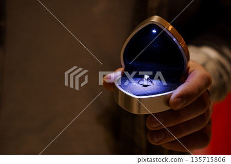 Elegant Heart-Shaped Ring Box with Diamond Engagement Ring Illuminated in Dark Setting 135715806