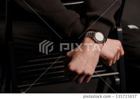 Close-Up of a Man Wearing a Silver Watch on His Wrist, Dark Background, Minimalist Style, Black Clothing, Modern Fashion 135715837
