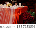 Romantic Red Table Setting with Rose Bouquet, Candles, and Fruit Arrangement in Theater Venue 135715854