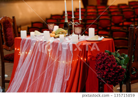Romantic Red Table Setting with Candles, Flowers, and Champagne in a Vintage Theater Romantic Red Table Setting with Candles, Flowers, and Champagne in a Vintage Theater 135715859