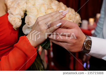 Romantic Engagement Ring Moment with White Roses and Red Dress in Elegant Wedding Proposal Scene 135715888