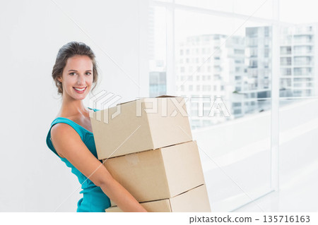 Smiling woman holding three cardboard boxes at apartment in turquoise sleeveless top, copy space Smiling woman holding three cardboard boxes at apartment in turquoise sleeveless top, copy space 135716163