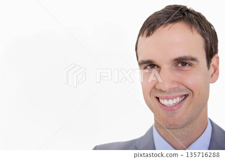 Adult man smiling, posing in studio portrait wearing grey suit and light blue shirt, copy space 135716288