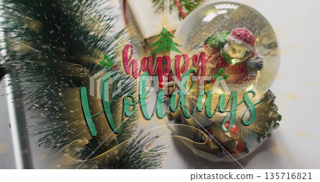 Happy Holidays text image over Christmas decorations with snowman snow globe Happy Holidays text image over Christmas decorations with snowman snow globe 135716821