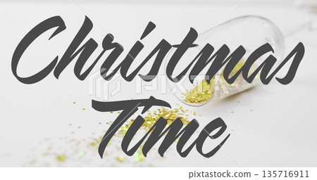 Image of christmas time text over glass of confetti 135716911