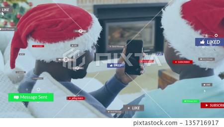 Social media notifications image over people wearing Santa hats and using smartphone 135716917