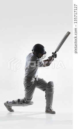 Cricket batsman kneeling power shot in studio isolated on white background. Cricket batsman kneeling power shot in studio isolated on white background. 135717127