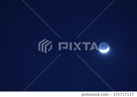 懸浮在空中的月亮。纖細的月亮與土星的合作。 135717137