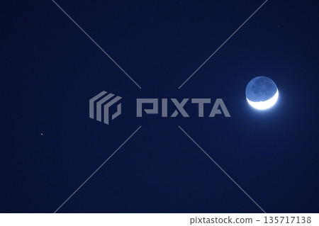 懸浮在空中的月亮。纖細的月亮與土星的合作。 懸浮在空中的月亮。纖細的月亮與土星的合作。 135717138