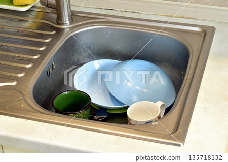 View of a sink with dirty dishes. View of a sink with dirty dishes. 135718132