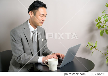 A man in a suit working in a cafe A man in a suit working in a cafe 135718296