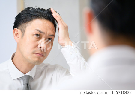 Men who care about hair in the mirror 135718422