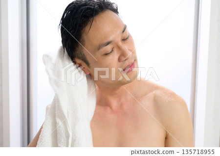 A man wiping his head with a towel A man wiping his head with a towel 135718955