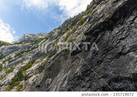 A towering rock cliff dominates the scene 135719072