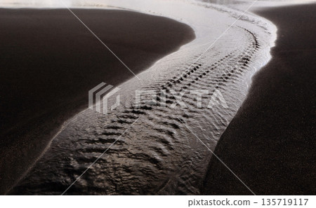 The gentle flow of water on the black sand beach 2 The gentle flow of water on the black sand beach 2 135719117