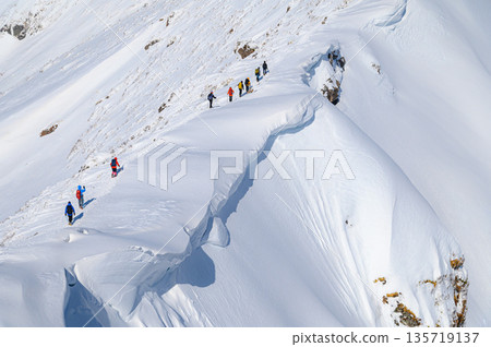 Climbers passing by a huge snow cornice on Mount Tanigawa in the dead of winter 135719137