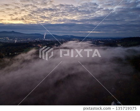 silent town shrouded in night fog, serene village beneath luminous lights and drifting clouds silent town shrouded in night fog, serene village beneath luminous lights and drifting clouds 135719375