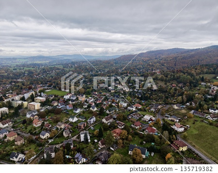 beautiful fall tableau featuring vibrant leaves on gentle hills with scattered residences nearby beautiful fall tableau featuring vibrant leaves on gentle hills with scattered residences nearby 135719382