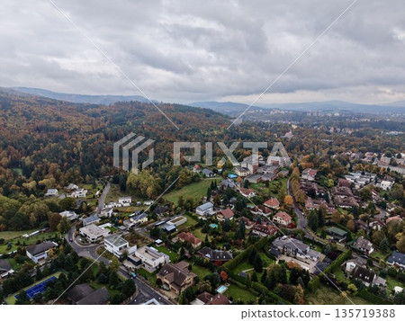 seasonal hamlet with colorful surroundings, autumnal settlement displaying vibrant foliage and quaint homes 135719388