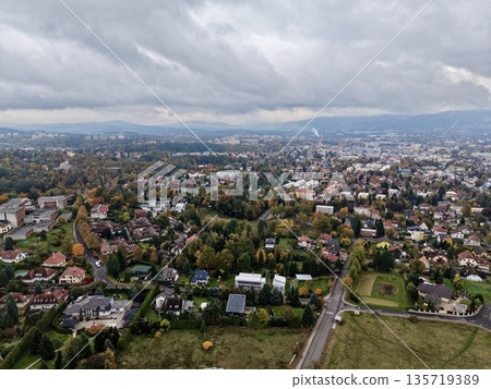 gateways through suburban neighborhoods stretching towards distant city skyline under cloudy horizon gateways through suburban neighborhoods stretching towards distant city skyline under cloudy horizon 135719389