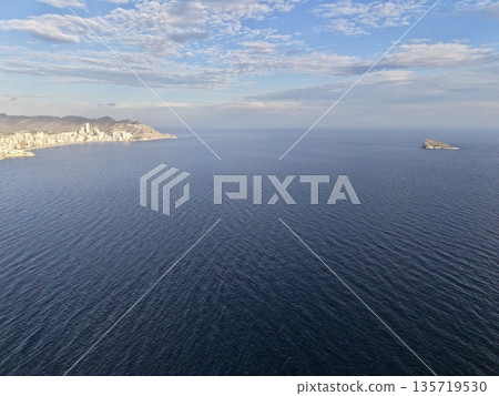 oceanic aerial scene, gorgeous aerial perspective of tranquil blue ocean and solitary stone formation 135719530