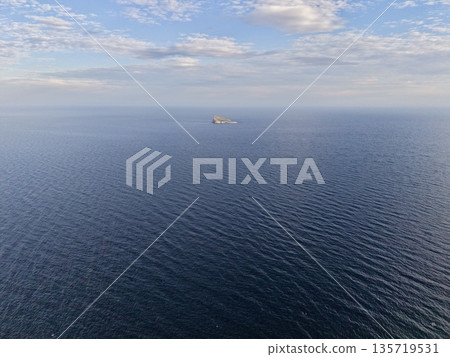 serene maritime vista, calm ocean with distant island, peaceful sea view showing horizon and ship serene maritime vista, calm ocean with distant island, peaceful sea view showing horizon and ship 135719531