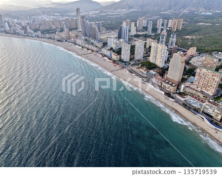 seaside dawn skyline, morning coastal city with waves, sunrise over tranquil shoreline and skyscrapers seaside dawn skyline, morning coastal city with waves, sunrise over tranquil shoreline and skyscrapers 135719539
