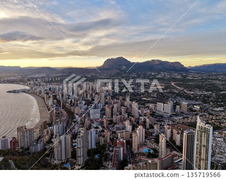 high city views at dusk, dusk skyline with towering buildings and scenic mountain background 135719566