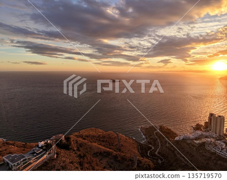 dusk over skyline and waves, twilight sky illuminates coastal skyline and tranquil waterscape scene dusk over skyline and waves, twilight sky illuminates coastal skyline and tranquil waterscape scene 135719570