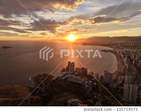 sunset bay tranquility, dusk illuminates coastal landscape featuring tranquil waters and distant towers sunset bay tranquility, dusk illuminates coastal landscape featuring tranquil waters and distant towers 135719573