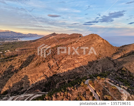 sunlit mountain landscape, bright dawn illuminating expansive cliffs and distant mountain ranges sunlit mountain landscape, bright dawn illuminating expansive cliffs and distant mountain ranges 135719631