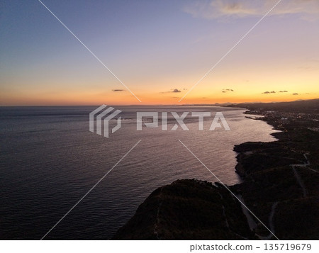 vivid coastal sunset, striking silhouette against colorful sky enhances visual storytelling potential 135719679