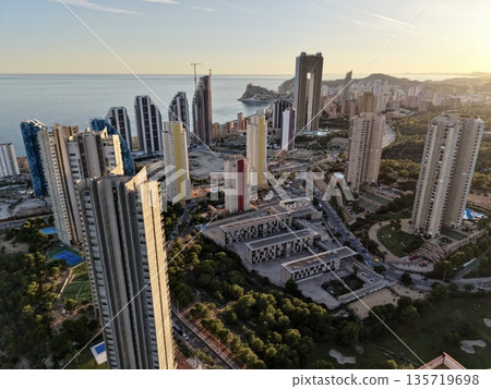 dawn over distant shoreline structures, serene sunrise over urban coast with quiet maritime scene dawn over distant shoreline structures, serene sunrise over urban coast with quiet maritime scene 135719698