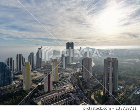 urban sunrise vista, bright hillside with foggy valley, morning glow over city with green spaces 135719711