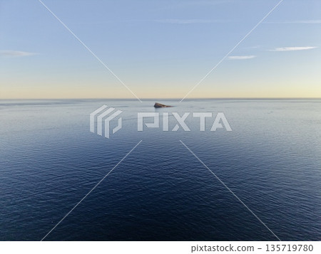 peaceful ocean voyage, tranquil seascape depicting solitary vessel on peaceful waters awaiting exploration 135719780