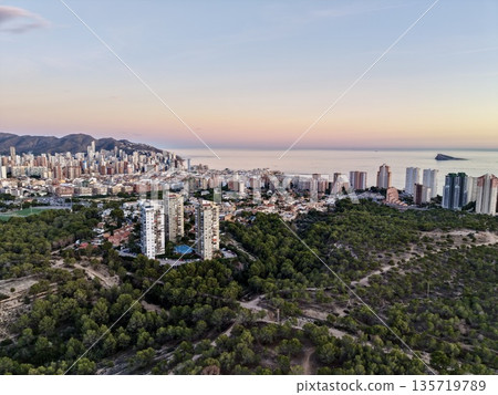 serene dusk hues, tranquil soft colored evening sky casting serenity on surroundings nearby woods and sea 135719789