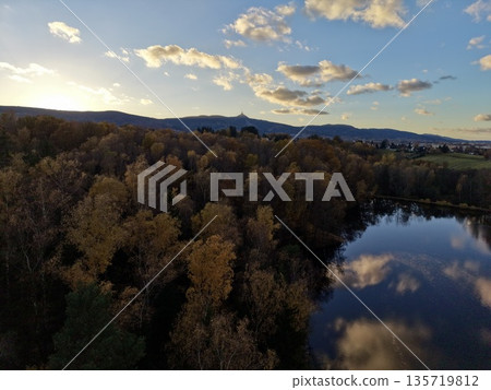 aerial perspective of peaceful lakeside scene at twilight with colorful foliage and distant mountains aerial perspective of peaceful lakeside scene at twilight with colorful foliage and distant mountains 135719812