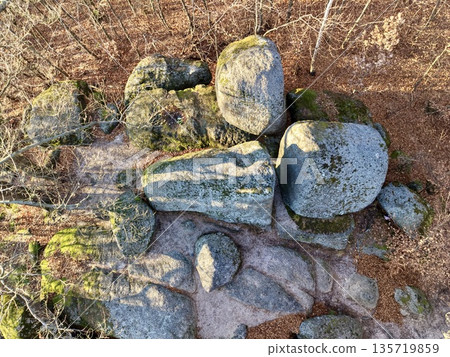 granite boulders in forest, closeup of textured granite and mossy boulders illuminated by warm sunlight 135719859