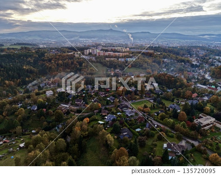 highaltitude photograph capturing urban neighborhoods amidst autumn forests and cloudy skies highaltitude photograph capturing urban neighborhoods amidst autumn forests and cloudy skies 135720095