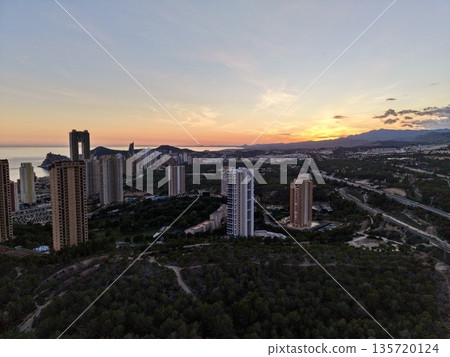 night city with bright lights, urban horizon during twilight featuring lit towers and bustling streets 135720124