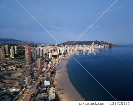 calm coastal town under night, nighttime harbor view with illuminated buildings and gentle waves calm coastal town under night, nighttime harbor view with illuminated buildings and gentle waves 135720125
