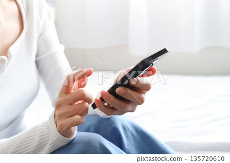 A woman operating a smartphone A woman operating a smartphone 135720610