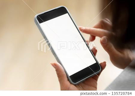Girl Holding Smartphone With White Screen In Hands 135720784