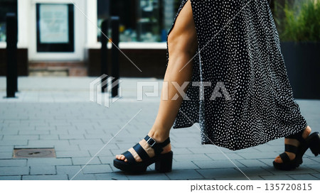 Stylish Young Woman In Dress With Naked Legs And High-Heeled Shoes Walking The Street 135720815