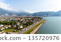 Aerial view of Fethiye coastal road with seaside promenade, residential houses, and mountains in the background. Calm daytime cityscape on the Mediterranean coast of Turkey. 135720976