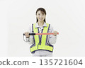 A young Japanese woman wearing work clothes with a safety belt and holding an emergency exit sign on a white background 135721604